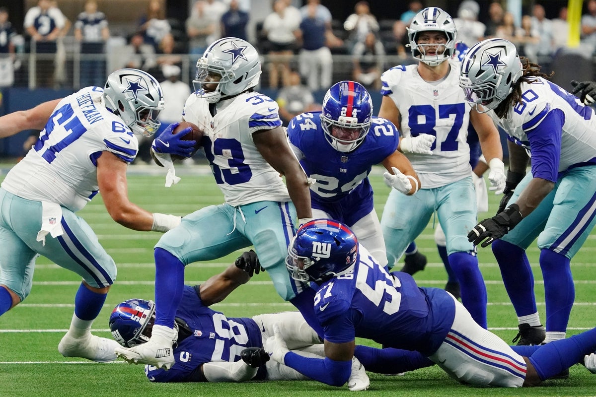 Sep 14, 2025; Arlington, Texas, USA; Dallas Cowboys running back Javonte Williams (33) runs with the ball against New York Giants defensive end Chauncey Golston (57) and safety Dane Belton (24) during overtime at AT&T Stadium. Mandatory Credit: Raymond Carlin III-Imagn Images