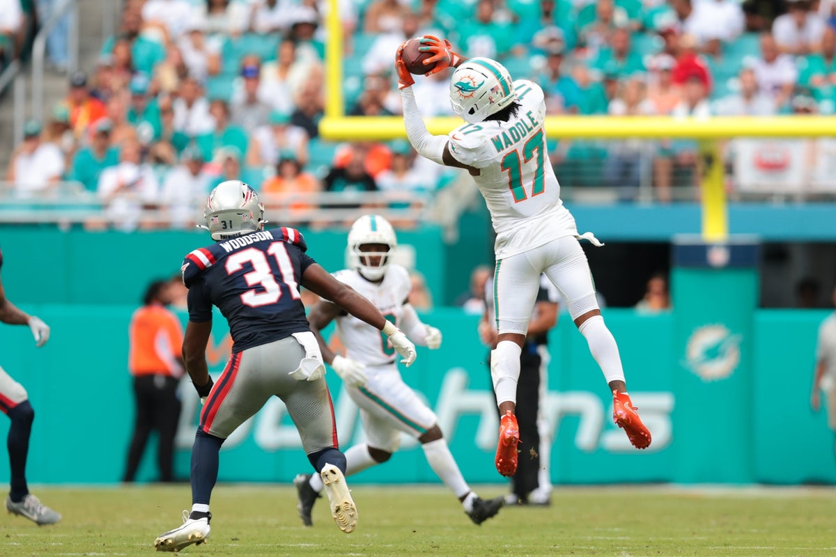 Sep 14, 2025; Miami Gardens, Florida, USA; Miami Dolphins wide receiver Jaylen Waddle (17) catches the football against New England Patriots safety Craig Woodson (31) during the fourth quarter at Hard Rock Stadium. Mandatory Credit: Sam Navarro-Imagn Images
