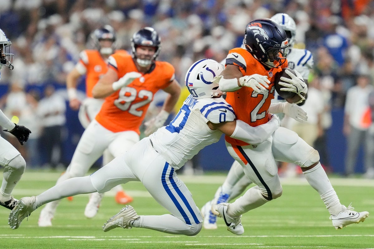 Indianapolis Colts safety Cam Bynum (0) tackles Denver Broncos running back J.K. Dobbins (27) on Sunday, Sept. 14, 2025, during a game at Lucas Oil Stadium in Indianapolis.