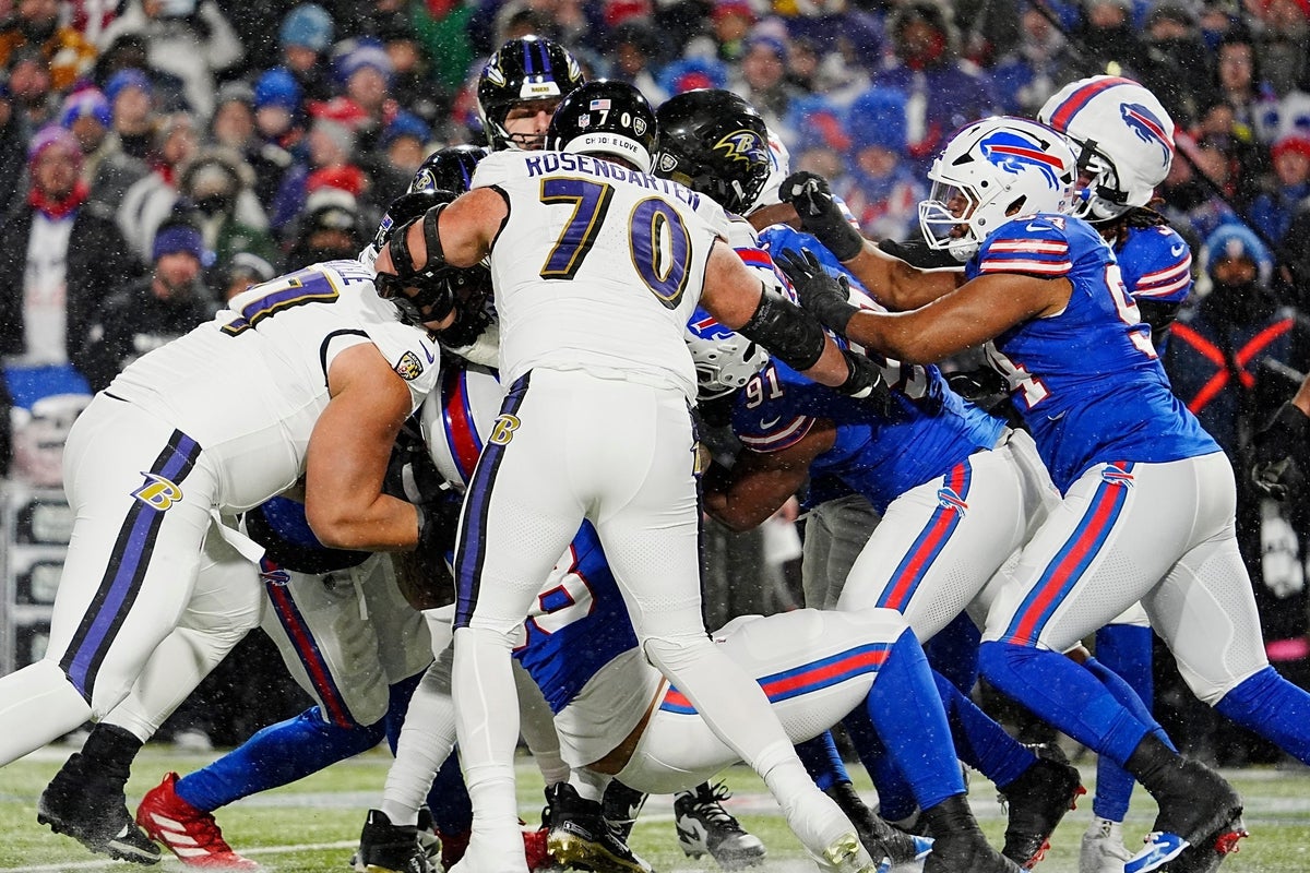 Baltimore Ravens running back Derrick Henry is caught by Buffalo Bills defensive end AJ Epenesa and is pushed back by Buffalo Bills defensive tackle Ed Oliver and Buffalo Bills defensive end Dawuane Smoot during first half action at the Buffalo Bills divisional game against the Baltimore Ravens at Highmark Stadium in Orchard Park on Jan. 19, 2025.