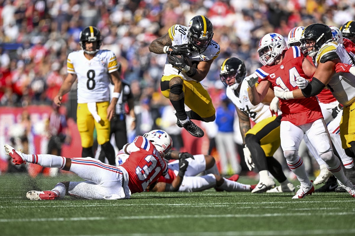 Sep 21, 2025; Foxborough, Massachusetts, USA; Pittsburgh Steelers running back Jaylen Warren (30) jumps over New England Patriots safety Craig Woodson (31) during the fourth quarter at Gillette Stadium. Mandatory Credit: Brian Fluharty-Imagn Images