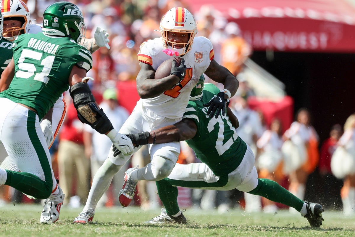 Sep 21, 2025; Tampa, Florida, USA; Tampa Bay Buccaneers running back Bucky Irving (7) runs with the ball as New York Jets cornerback Brandon Stephens (21) defends during the second half at Raymond James Stadium. Mandatory Credit: Kim Klement Neitzel-Imagn Images