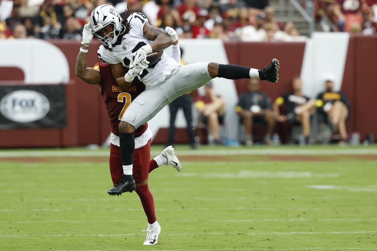 Sep 21, 2025; Landover, Maryland, USA; Las Vegas Raiders wide receiver Jakobi Meyers (16) leaps to make a catch in front of Washington Commanders cornerback Marshon Lattimore (2) during the third quarter at Northwest Stadium. Mandatory Credit: Geoff Burke-Imagn Images