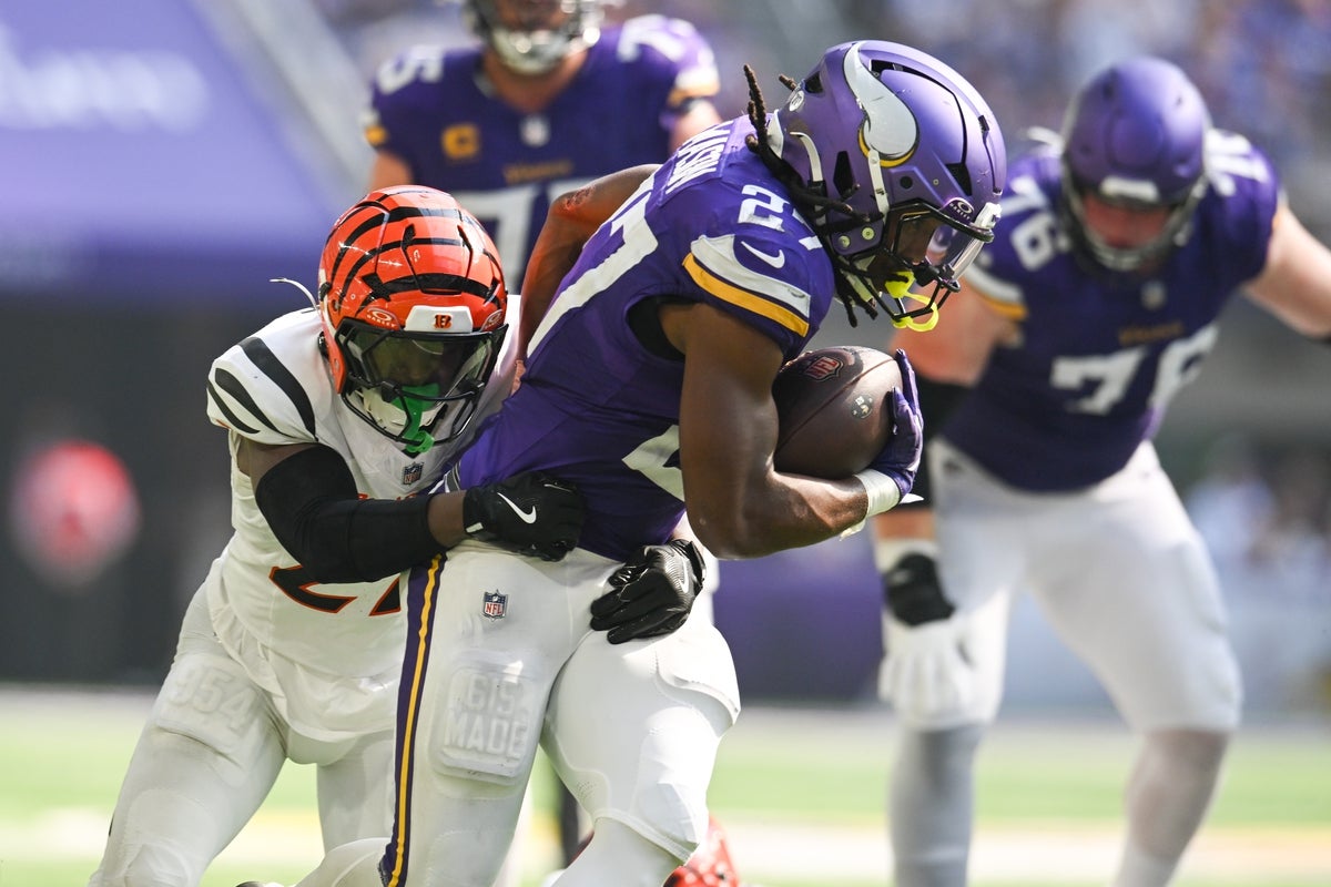 Sep 21, 2025; Minneapolis, Minnesota, USA; Minnesota Vikings running back Jordan Mason (27) is tackled by Cincinnati Bengals safety Jordan Battle (27) during the second half at U.S. Bank Stadium. Mandatory Credit: Jeffrey Becker-Imagn Images