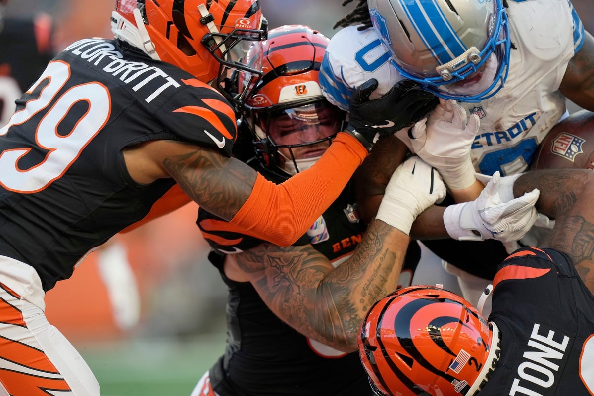 Cincinnati Bengals cornerback Cam Taylor-Britt (29), left, Bengals linebacker Logan Wilson (55) and Bengals safety Geno Stone (22) try to take down Detroit Lions running back Jahmyr Gibbs (0) in the 3rd quarter at Paycor Stadium on October 5, 2025. The Bengals lost 24-37.