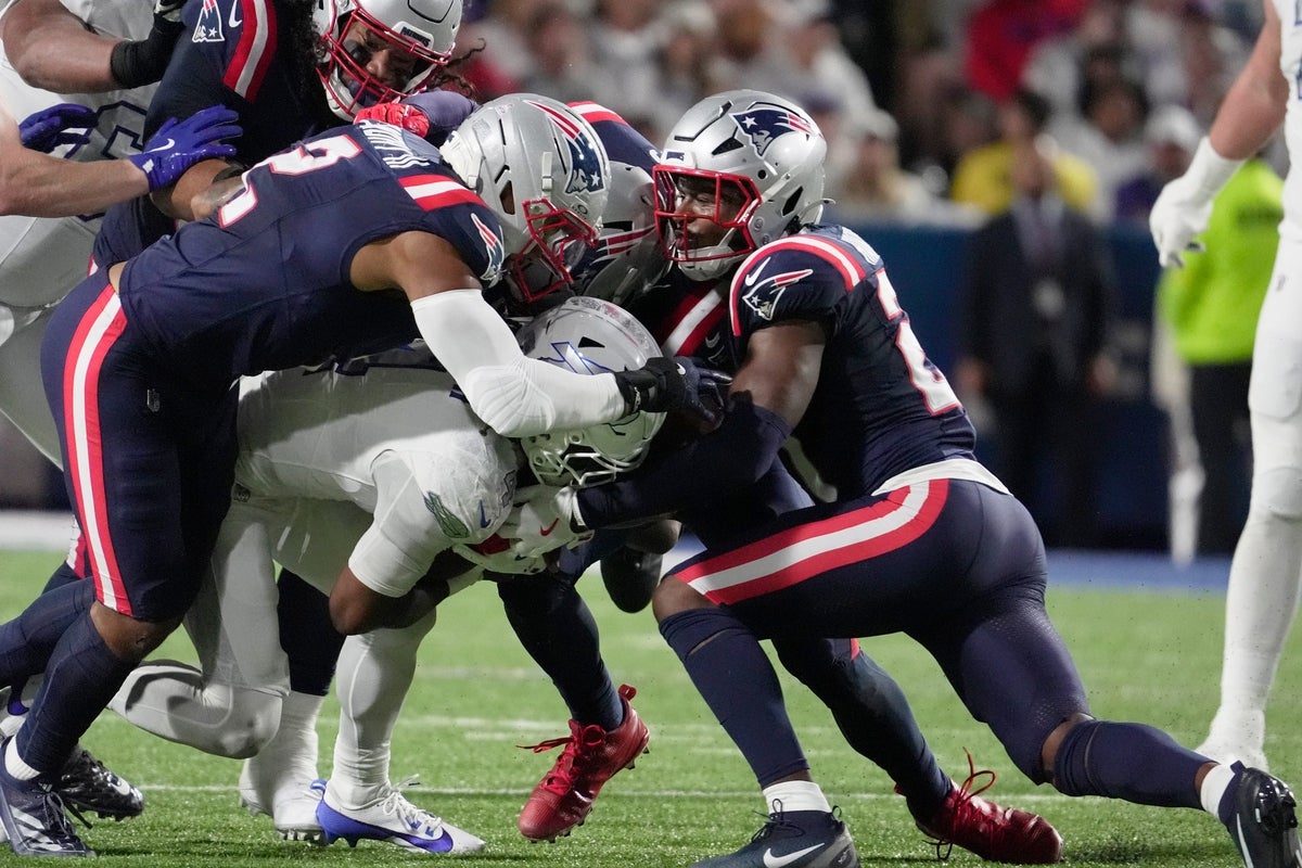 Buffalo Bills running back James Cook protects the ball while hands reach for it while he’s being taken down by a trio of Patriot players during first half action at Highmark Stadium in Orchard Park on Oct. 5, 2025.