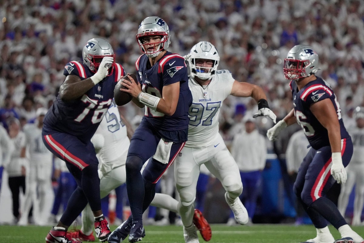 New England Patriots quarterback Drake Maye looks for a receiver during first half action at Highmark Stadium in Orchard Park on Oct. 5, 2025. Behind him Bills Joey Bosa heads towards him hoping to sack him.