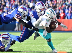 Jan 15, 2023; Orchard Park, NY, USA; Miami Dolphins wide receiver Tyreek Hill (10) tries to get away from Buffalo Bills cornerback TreDavious White (27) and safety Jordan Poyer (21) and cornerback Taron Johnson (7) during the first half in a NFL wild card game at Highmark Stadium. Mandatory Credit: Mark Konezny-USA TODAY Sports