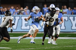 Sep 9, 2023; Chapel Hill, North Carolina, USA; North Carolina Tar Heels quarterback Drake Maye (10) with the ball as Appalachian State Mountaineers linebacker Andrew Parker Jr. (7) and defensive end Shawn Collins (12) defend in the fourth quarter at Kenan Memorial Stadium. Mandatory Credit: Bob Donnan-USA TODAY Sports